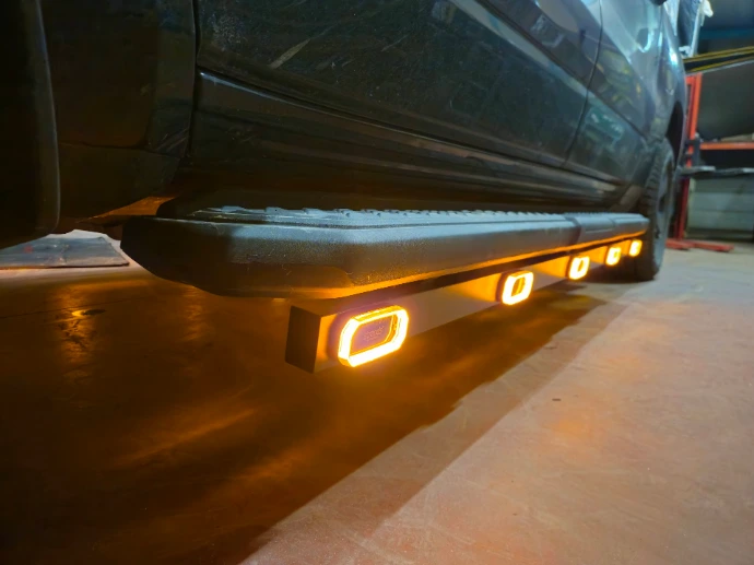 Robuuste, opbouw LED-werkklamp gemonteerd aan het chassis van een bedrijfsvoertuig voor functionele werkplekverlichting.