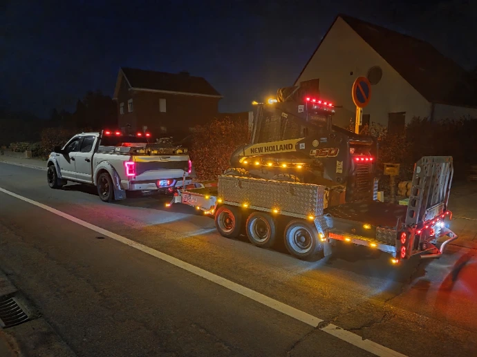 Zwarte pick-up truck voorzien van oranje LED-contourverlichting langs de carrosserie voor verbeterde zichtbaarheid in het donker.
